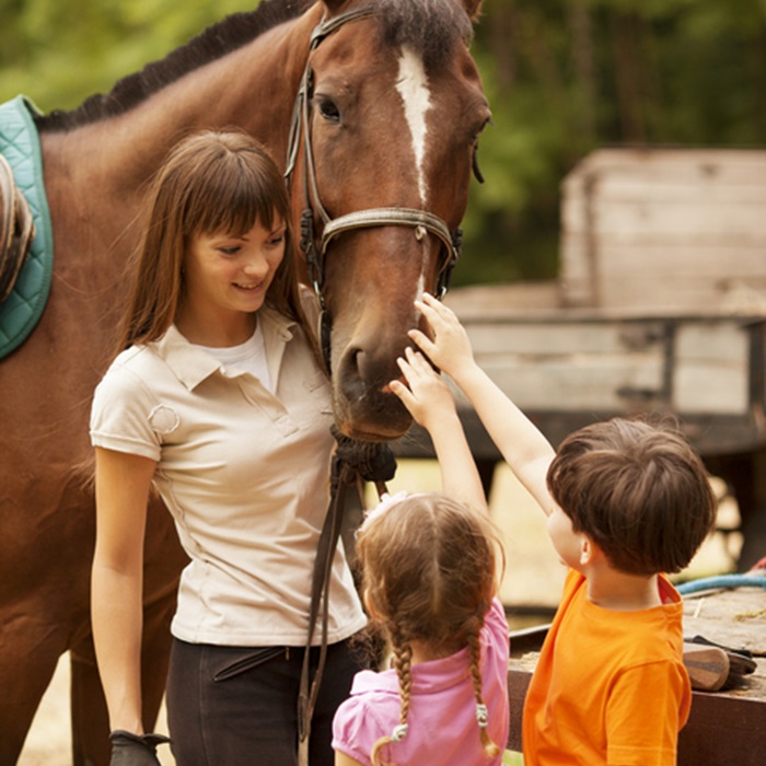 Horse_Instructor_Brokers Equine instructor teaching two children about horses.